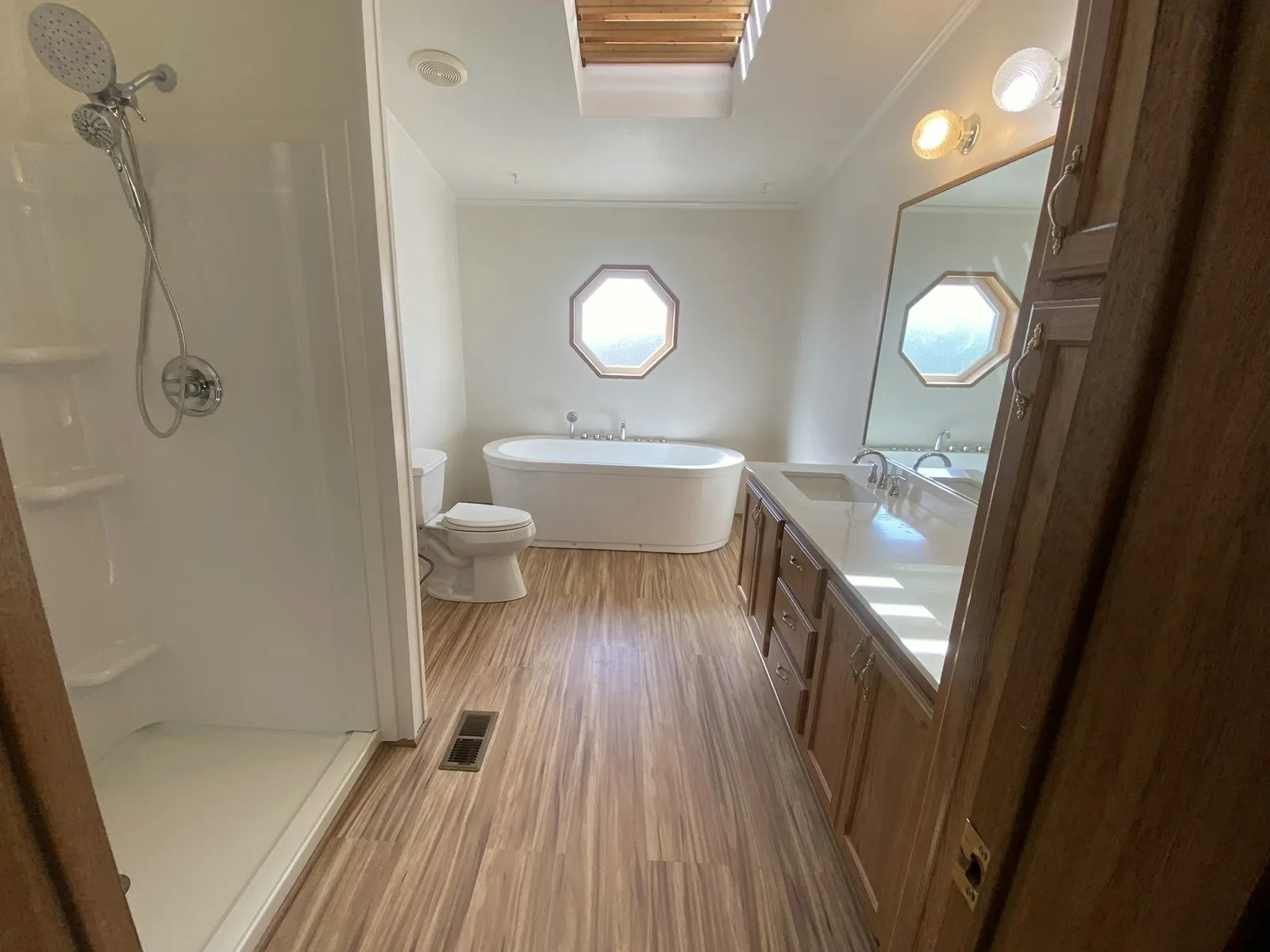 A finished bathroom with a soaking tub, walk-in shower and long double vanity